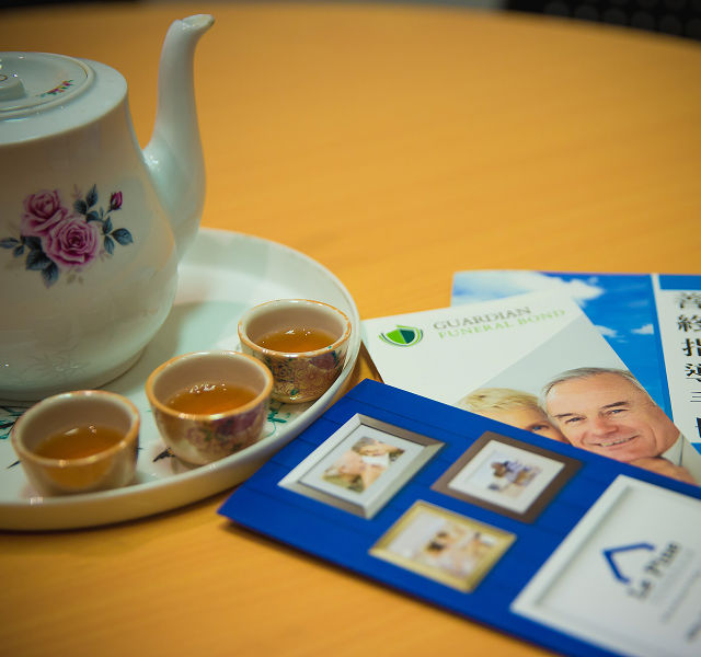Image of a teapot with three small tea cups with team in them next to some pamphlets